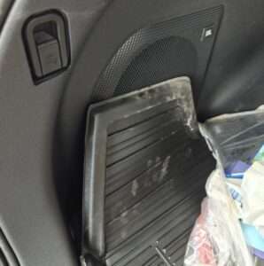 Bagagerum i Toyota bZ4X før 2026 med bagagerumsmåtte med to sidefløje og JBL subwoofer i sidepanel